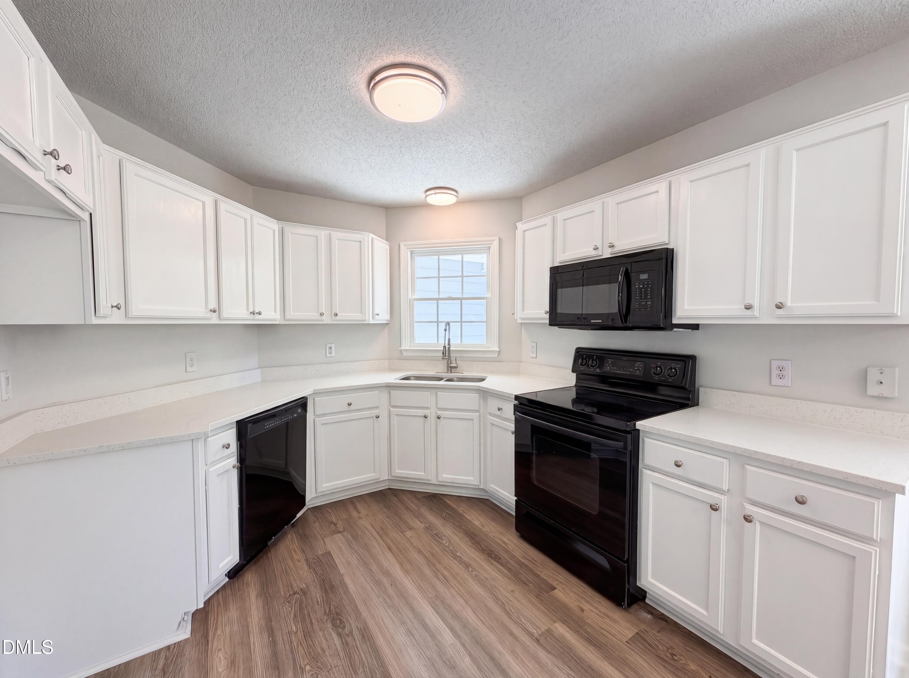 765 Trebor Drive Garner, NC 27529 - Photo 2 of 27 a kitchen with granite countertop white cabinets and black stainless steel appliances