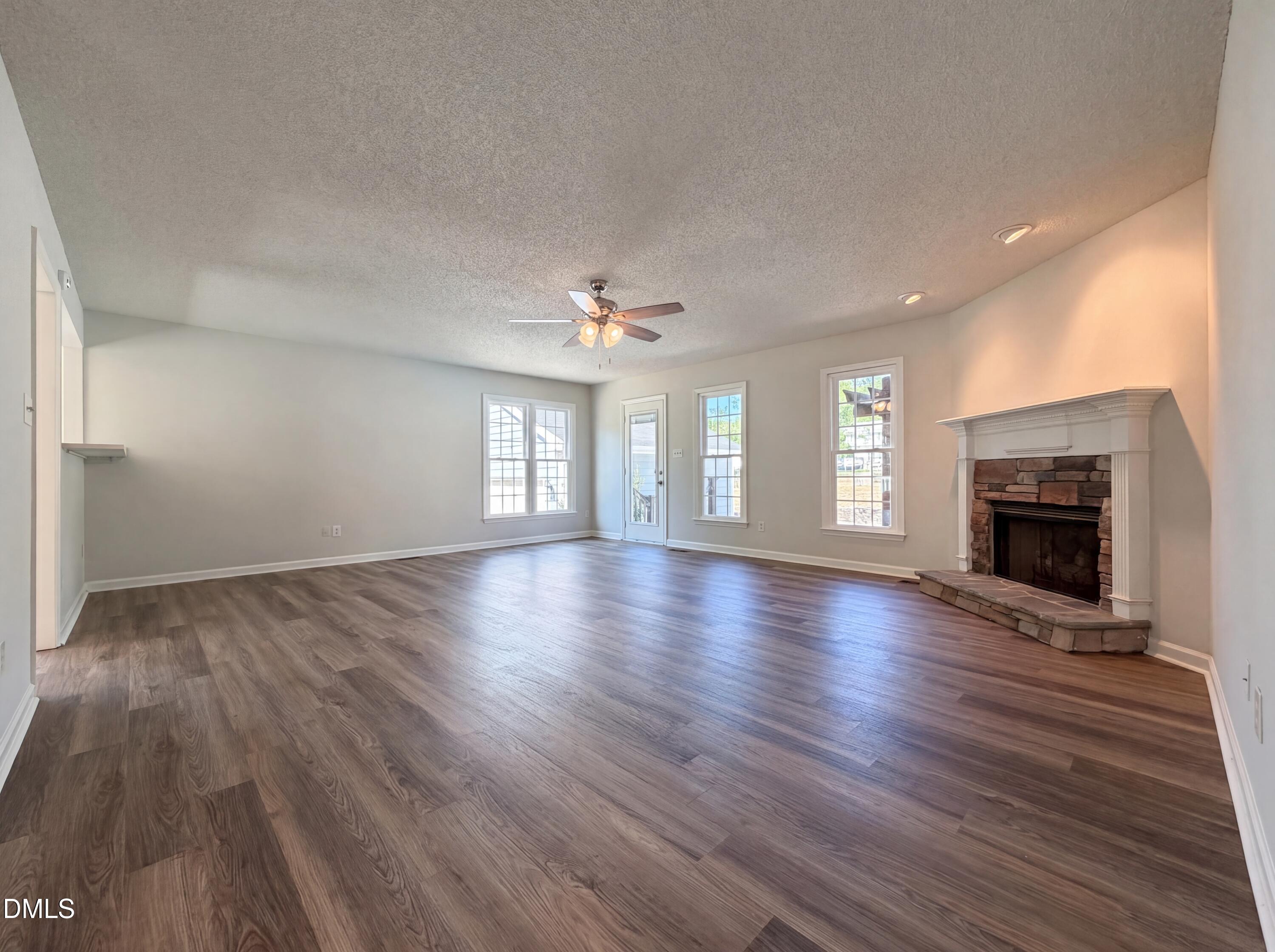 765 Trebor Drive Garner, NC 27529 - Photo 3 of 27 an empty room with wooden floor fireplace and windows
