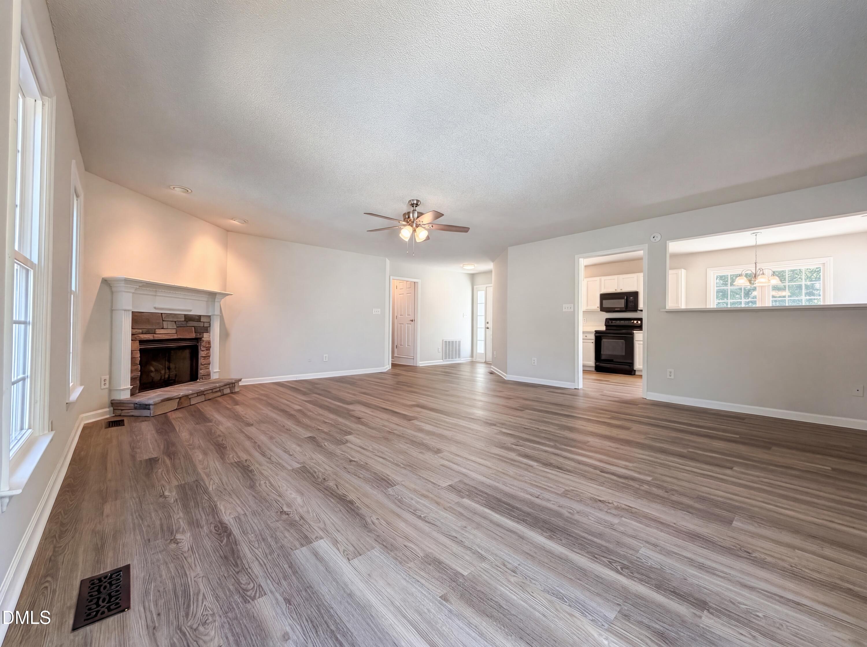 765 Trebor Drive Garner, NC 27529 - Photo 9 of 27 an empty room with wooden floor fireplace and windows
