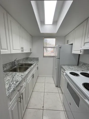 a kitchen with a stove sink and cabinets