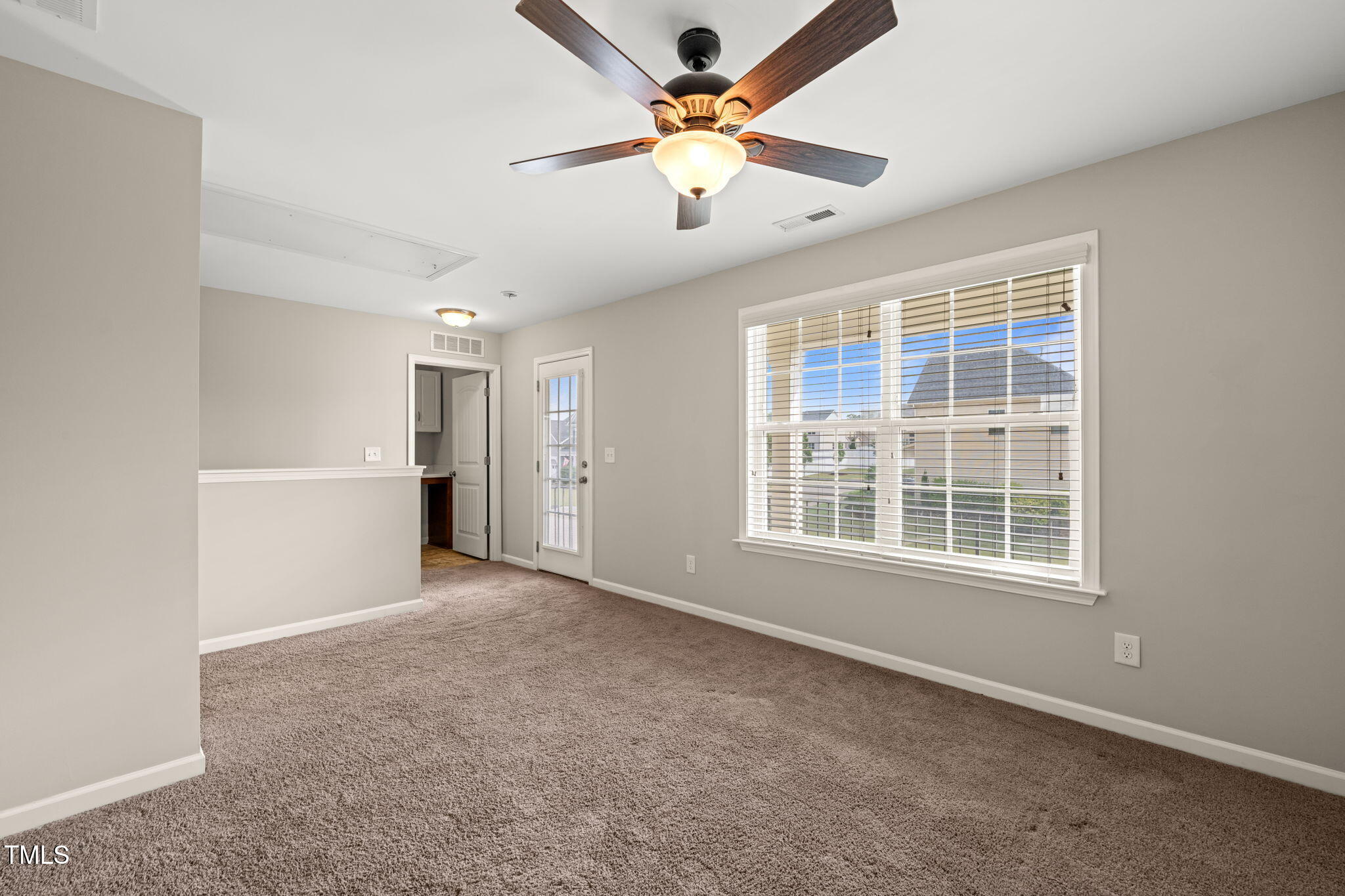 5011 Peachtree Town Lane Knightdale, NC 27545 - Photo 22 of 47 an empty room with chandelier fan and windows
