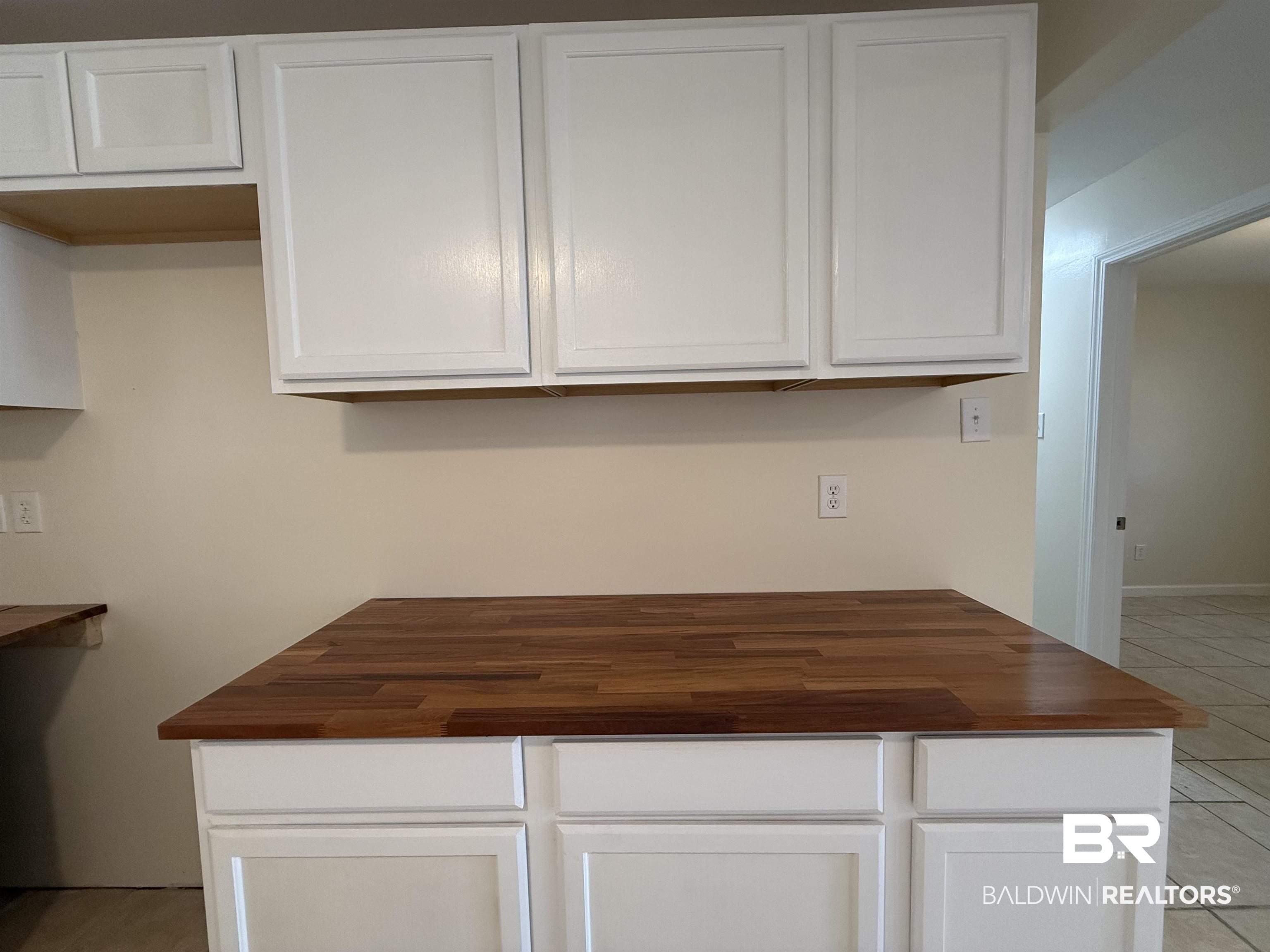 320 E Street Prichard, AL 36610 - Photo 15 of 16 Kitchen featuring light tile patterned flooring, wood counters, and white cabinetry