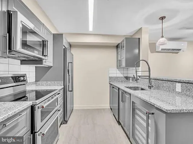a kitchen with stainless steel appliances granite countertop a sink and stove top oven