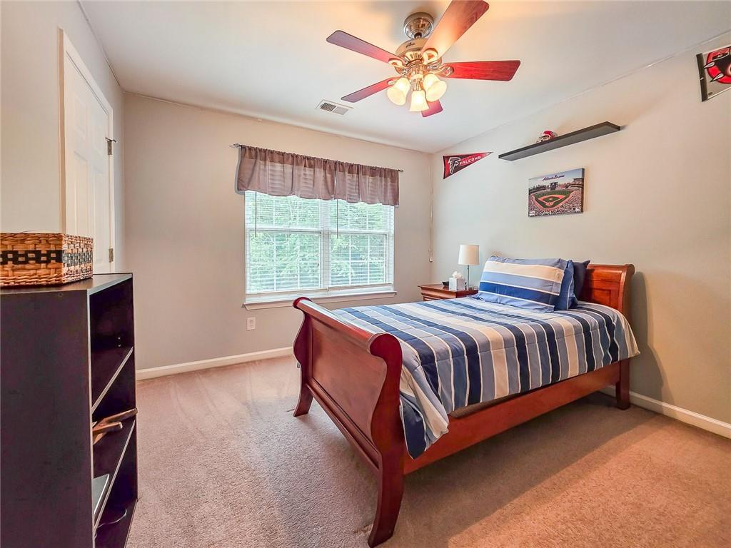 43 Ivy Mist Lane Acworth, GA 30101 - Photo 22 of 58 a spacious bedroom with a bed and a chandelier