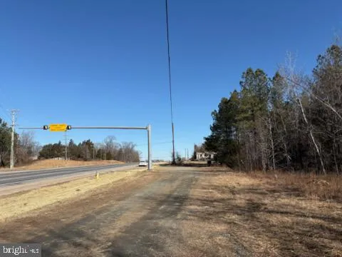 a view of dirt field with trees in the background