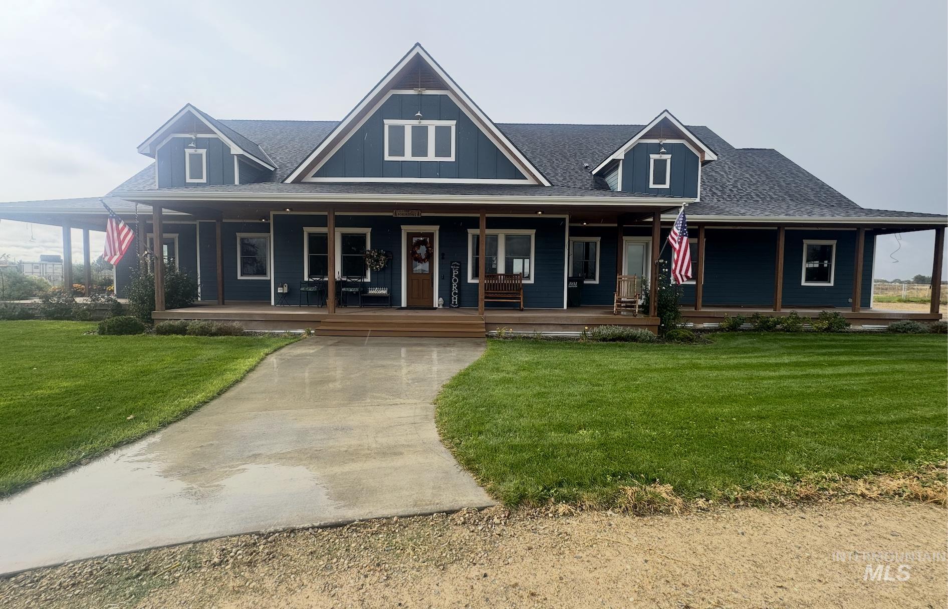 Farmhouse with covered porch, a front lawn, and roof with shingles