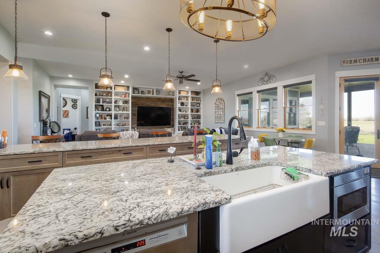 415 North Locust Grove Road Kuna, ID 83634 - Photo 46 of 49 Kitchen with built in features, light stone countertops, open floor plan, stainless steel appliances, and recessed lighting
