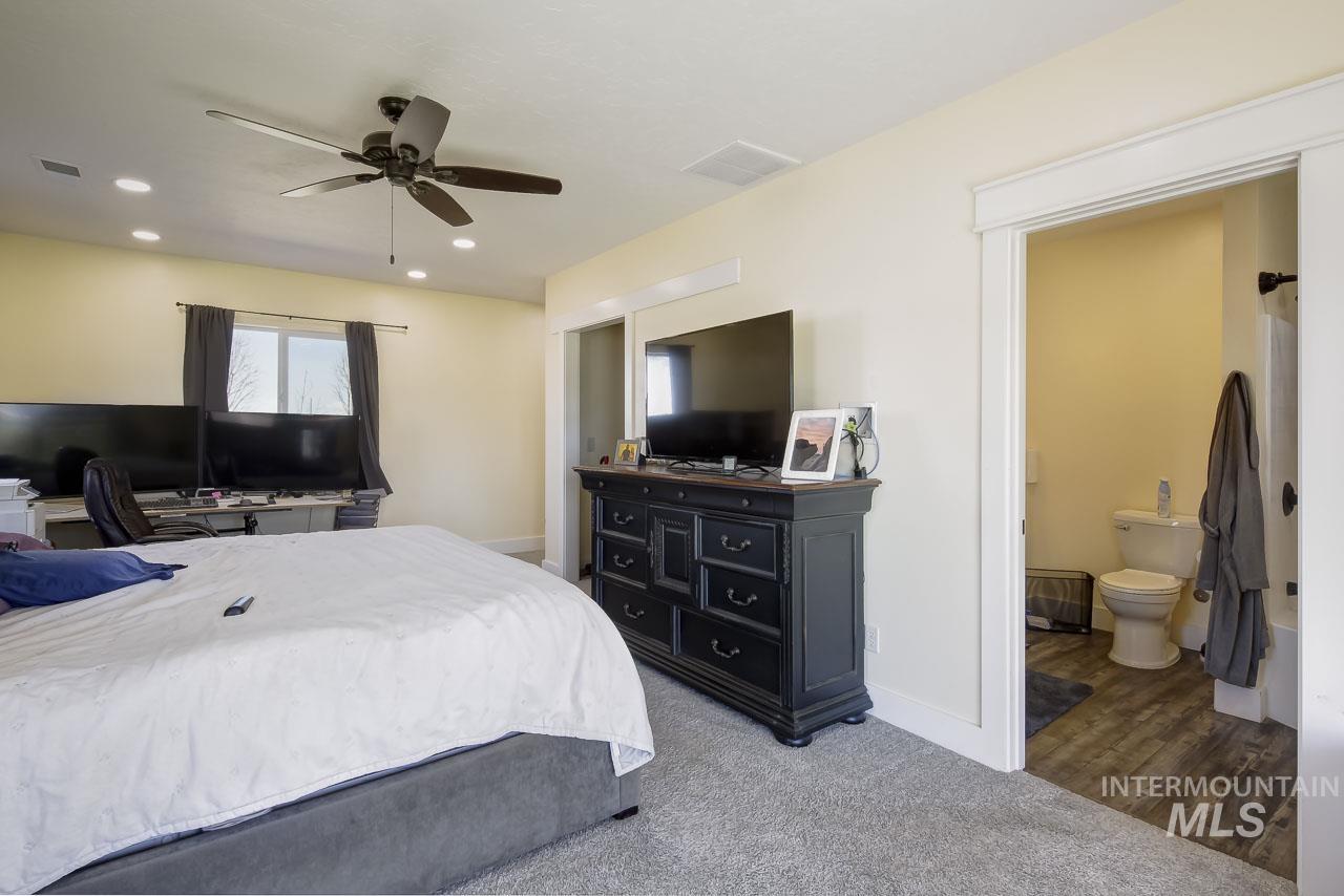 415 North Locust Grove Road Kuna, ID 83634 - Photo 42 of 49 Bedroom with light colored carpet, a ceiling fan, recessed lighting, and ensuite bathroom