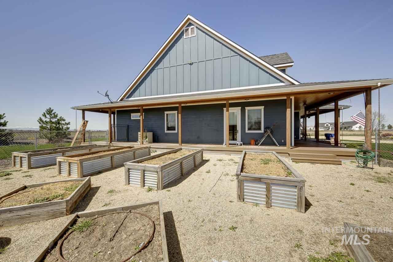 415 North Locust Grove Road Kuna, ID 83634 - Photo 5 of 49 Back of property with board and batten siding and a garden
