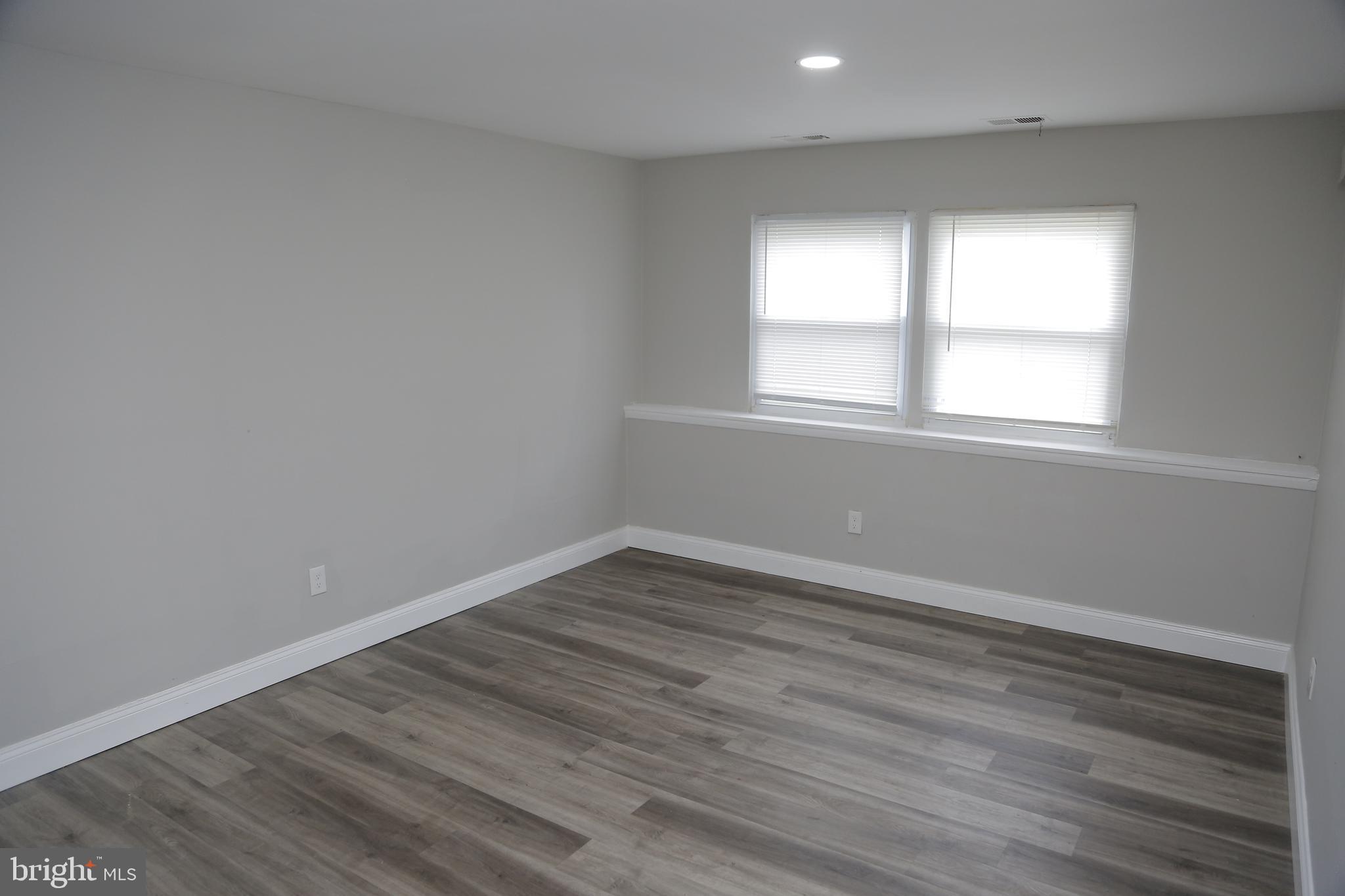 4209 Ridgewood Avenue, Unit 4 Baltimore, MD 21215 - Photo 1 of 17 an empty room with wooden floor and windows