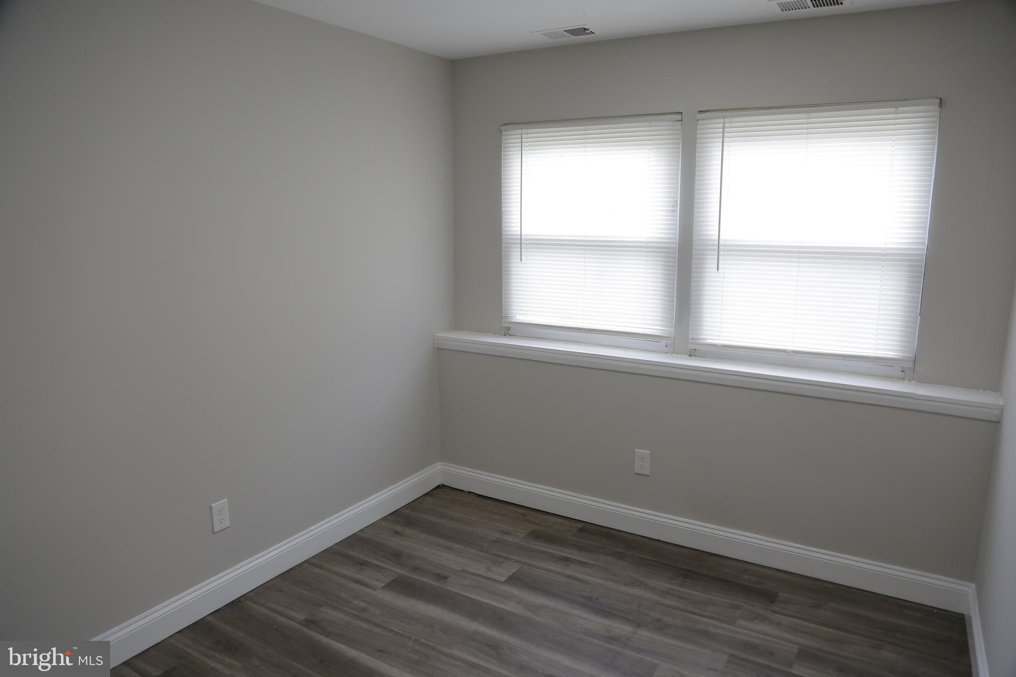4209 Ridgewood Avenue, Unit 4 Baltimore, MD 21215 - Photo 11 of 17 an empty room with wooden floor and windows