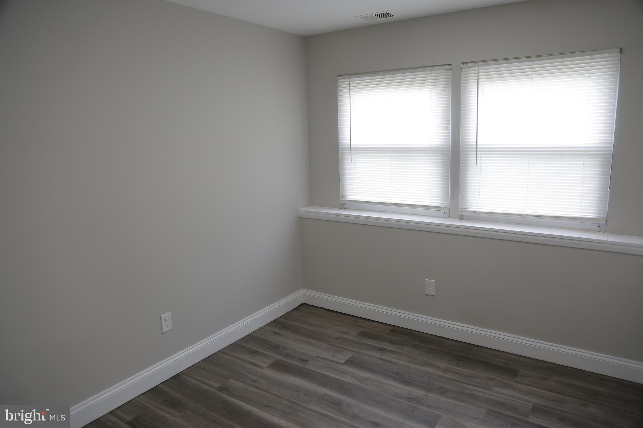 4209 Ridgewood Avenue, Unit 4 Baltimore, MD 21215 - Photo 12 of 17 an empty room with wooden floor and windows