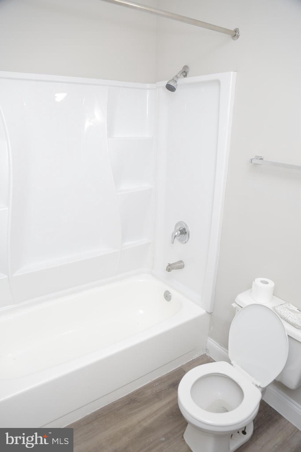 4209 Ridgewood Avenue, Unit 4 Baltimore, MD 21215 - Photo 15 of 17 a white toilet and tub next to a white cabinet