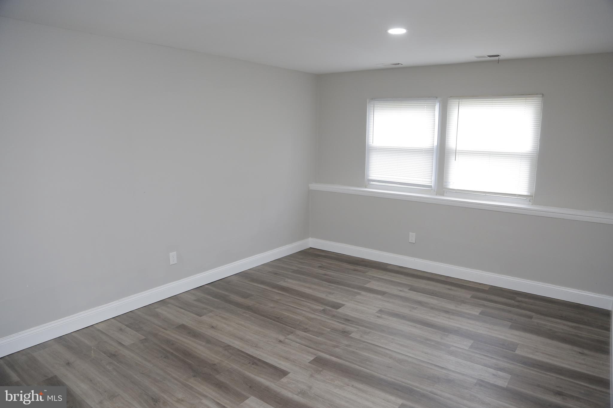 4209 Ridgewood Avenue, Unit 4 Baltimore, MD 21215 - Photo 2 of 17 an empty room with wooden floor and windows
