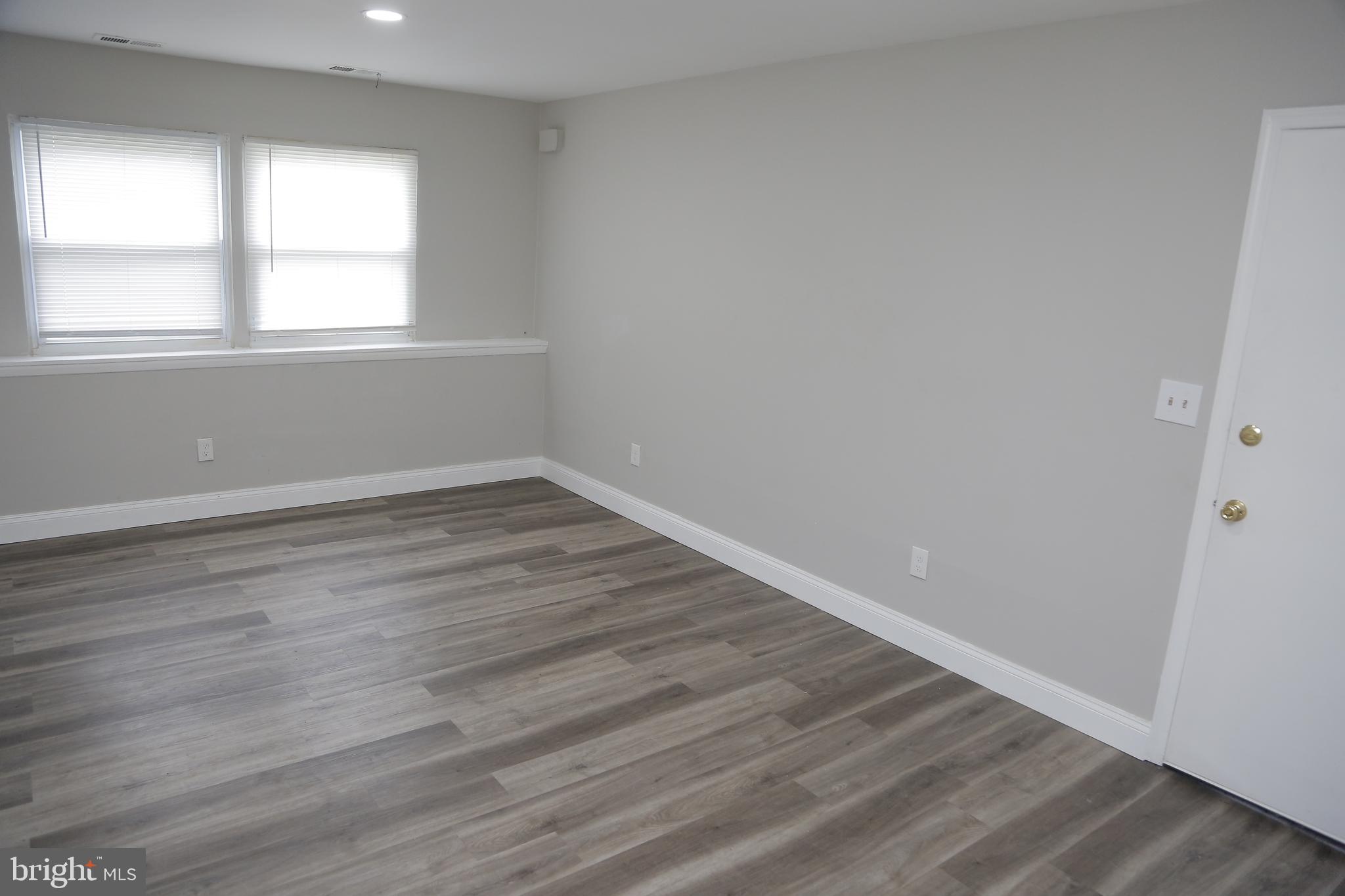 4209 Ridgewood Avenue, Unit 4 Baltimore, MD 21215 - Photo 4 of 17 wooden floor in an empty room with a window