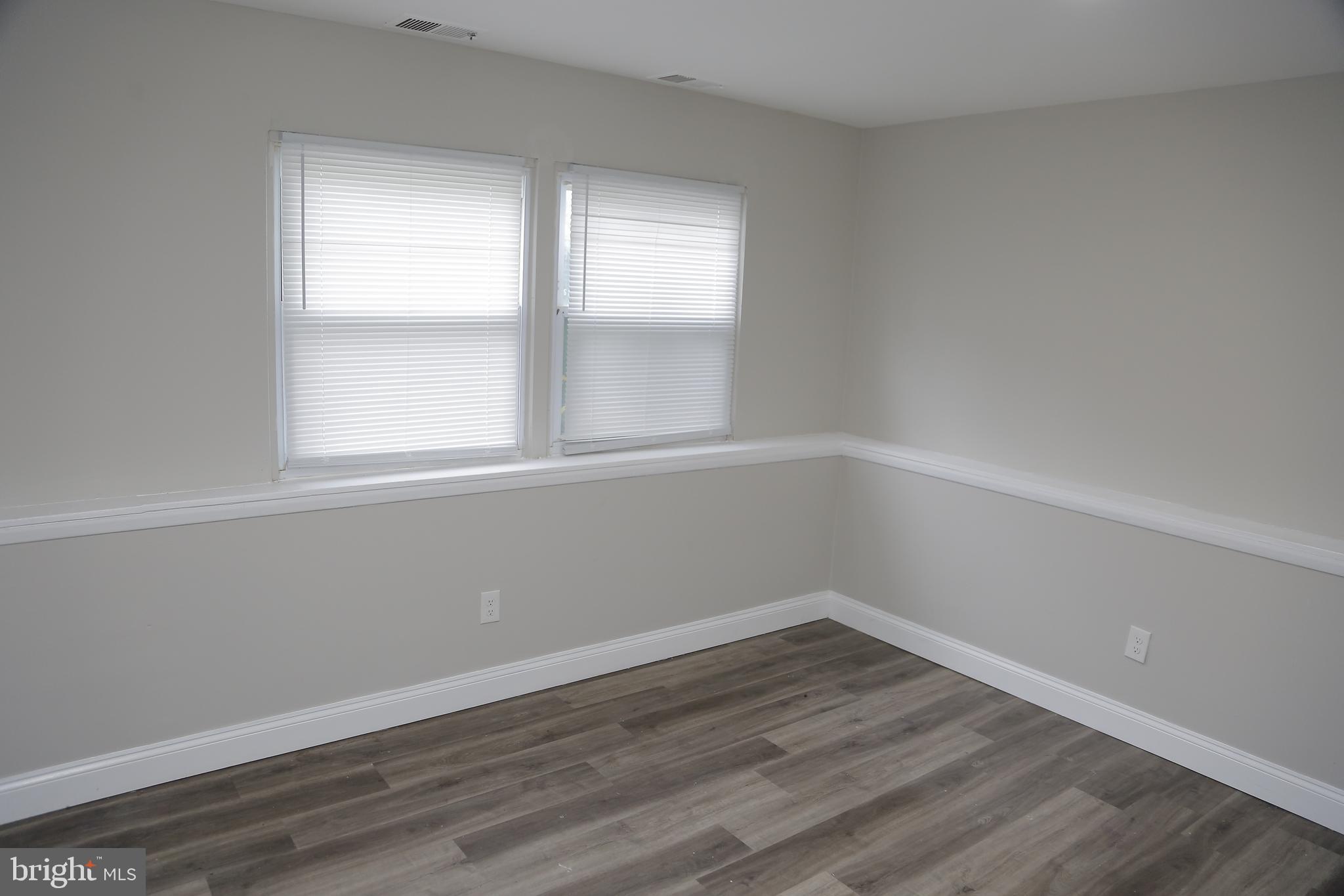 4209 Ridgewood Avenue, Unit 4 Baltimore, MD 21215 - Photo 7 of 17 an empty room with wooden floor and windows