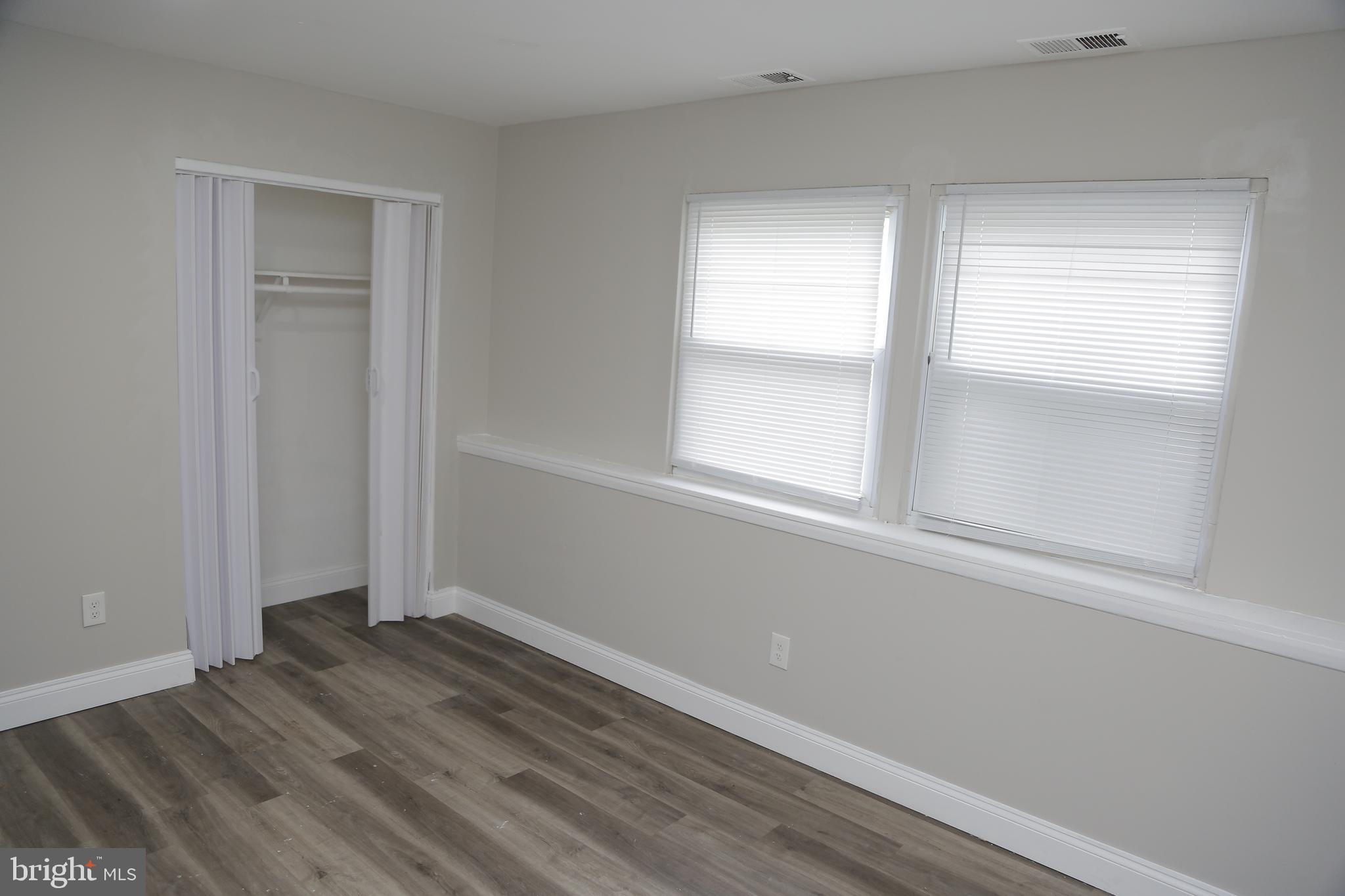 4209 Ridgewood Avenue, Unit 4 Baltimore, MD 21215 - Photo 8 of 17 a view of an empty room with wooden floor and a window