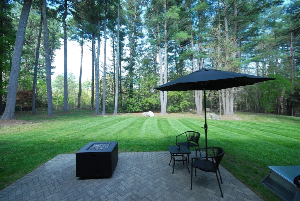 136 Holden Wood Road Concord, MA 01742 - Photo 23 of 31 a view of backyard with a table and chairs under an umbrella