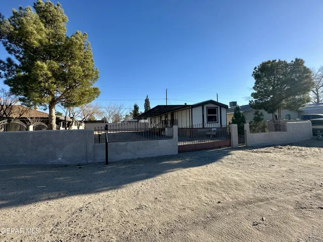 a view of a house with wooden fence