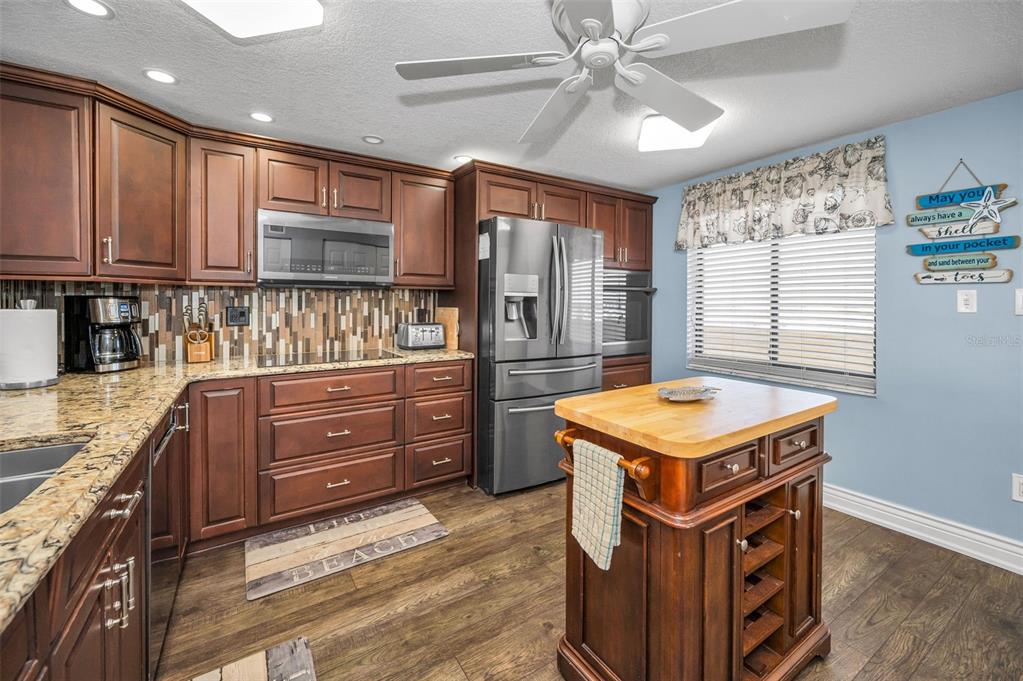 14950 Gulf Boulevard, Unit 1206 Madeira Beach, FL 33708 - Photo 13 of 69 a kitchen with a stove and a refrigerator