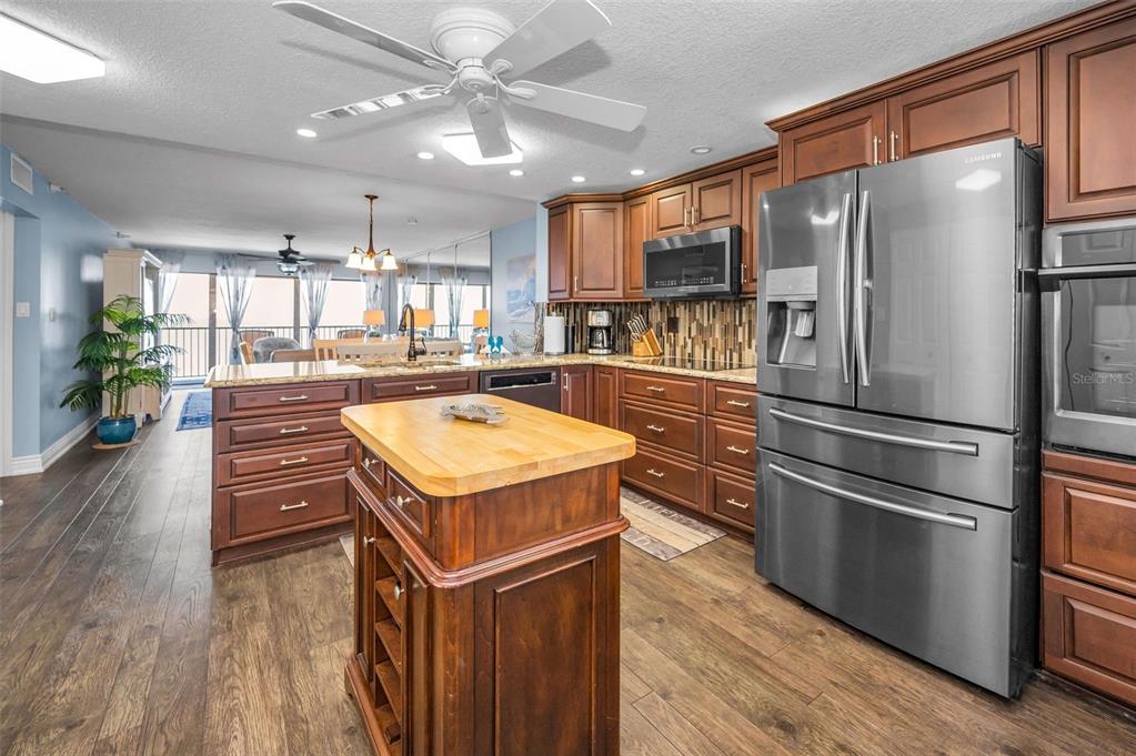 14950 Gulf Boulevard, Unit 1206 Madeira Beach, FL 33708 - Photo 14 of 69 a kitchen with a refrigerator a sink and wooden floor