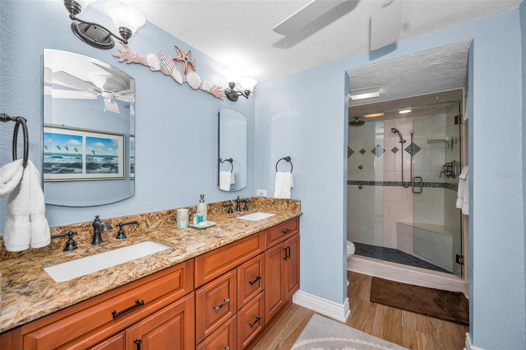 14950 Gulf Boulevard, Unit 1206 Madeira Beach, FL 33708 - Photo 21 of 69 a bathroom with a granite countertop sink and a mirror
