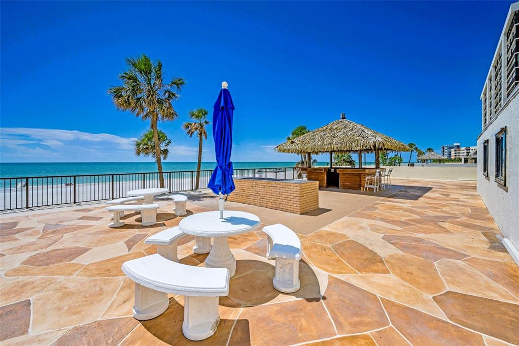 14950 Gulf Boulevard, Unit 1206 Madeira Beach, FL 33708 - Photo 43 of 69 a view of a patio with a table and chairs under an umbrella