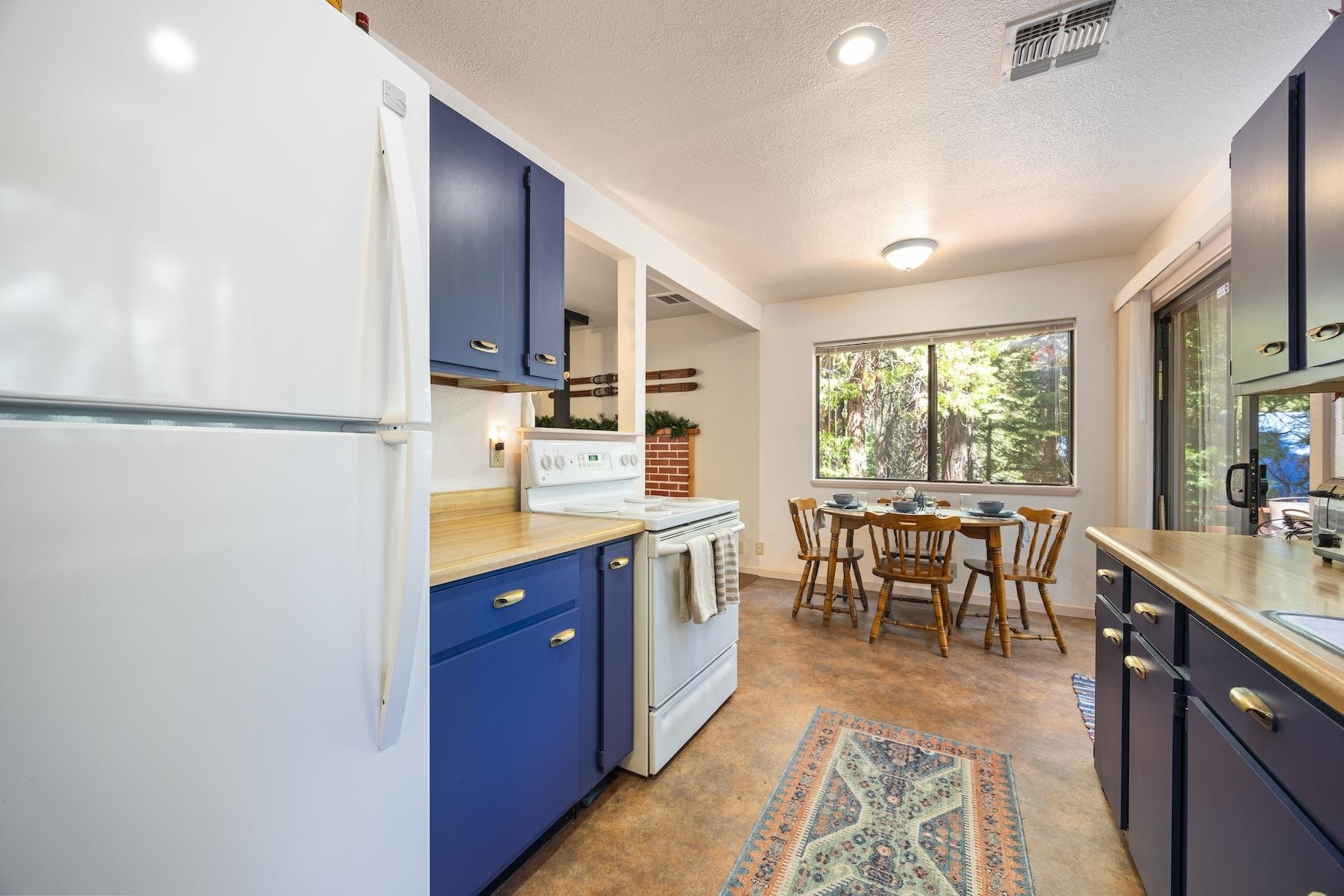 41080 Putt Road Emigrant Gap, CA 95715 - Photo 7 of 21 a kitchen with kitchen island granite countertop a sink a stove a refrigerator with a dining table and chairs