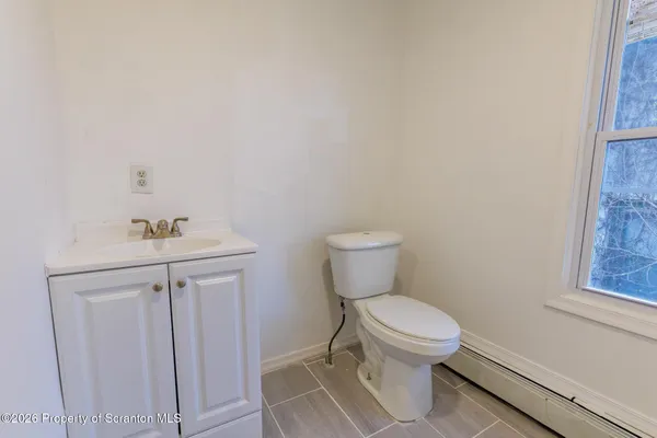 a bathroom with a toilet a window and shower