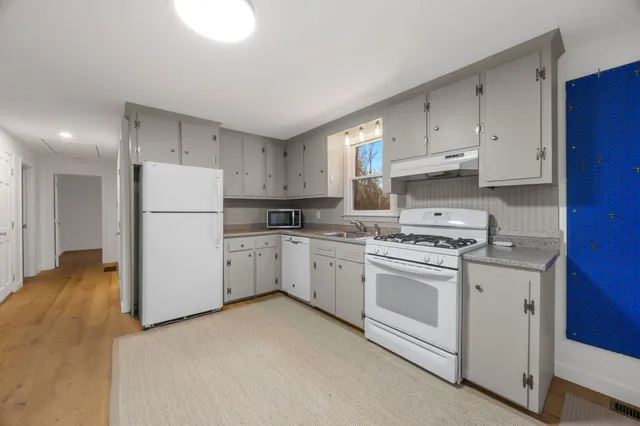 a kitchen with cabinets appliances a sink and a counter top space
