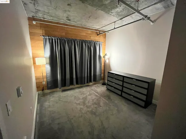 a view of a room with wooden walls and a window