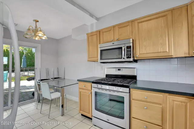 a kitchen with granite countertop wooden cabinets and stainless steel appliances