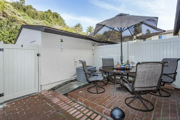 a view of a patio with table and chairs under an umbrella