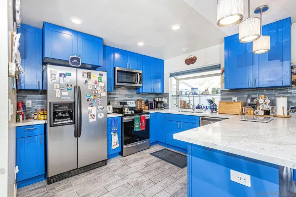 a kitchen with stainless steel appliances kitchen island granite countertop a refrigerator stove and sink
