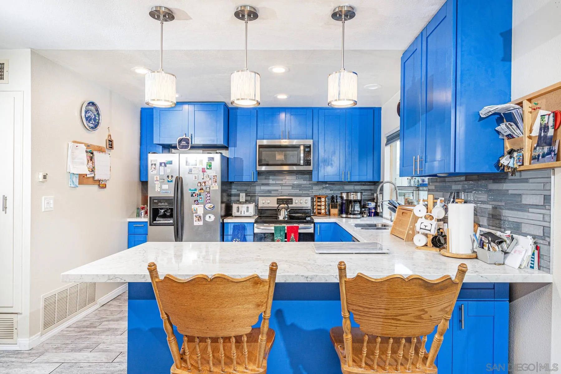 3433 Fairlomas Road National City, CA 91950 - Photo 9 of 43 a kitchen with stainless steel appliances wooden floors wooden cabinets a dining table and chairs