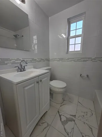 a bathroom with a sink toilet and window