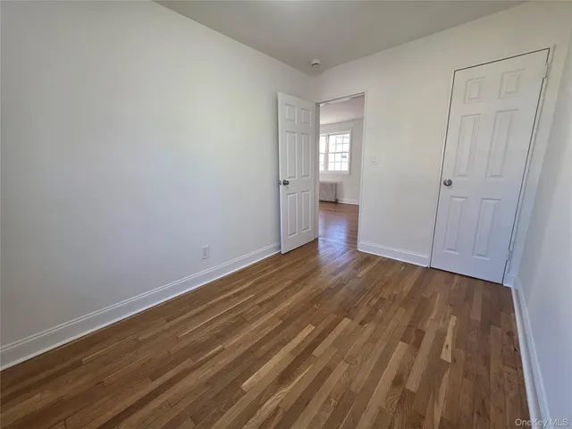 a view of a room with wooden floor and windows