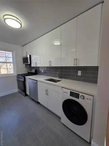 a kitchen with a sink cabinets and stainless steel appliances