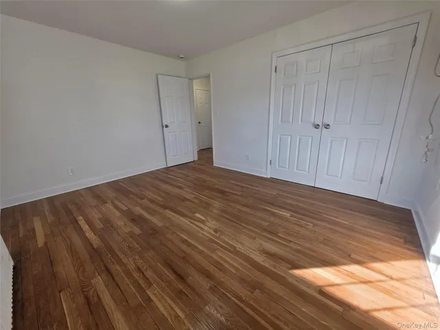 a view of empty room with wooden floor and entryway