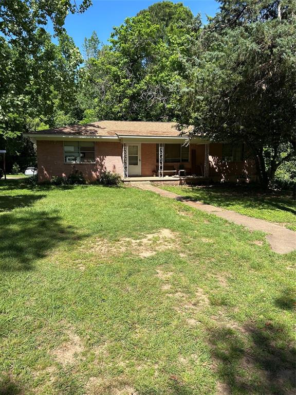 4514 West Loop 281 Longview, TX 75604 - Photo 15 of 36 Brick exterior residence featuring a covered front porch, a light-colored entry door, and a shingle roof