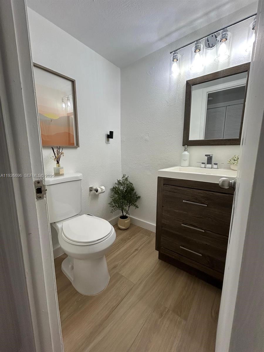5838 Collins Avenue, Unit 11D Miami Beach, FL 33140 - Photo 11 of 24 a bathroom with a toilet a sink and mirror