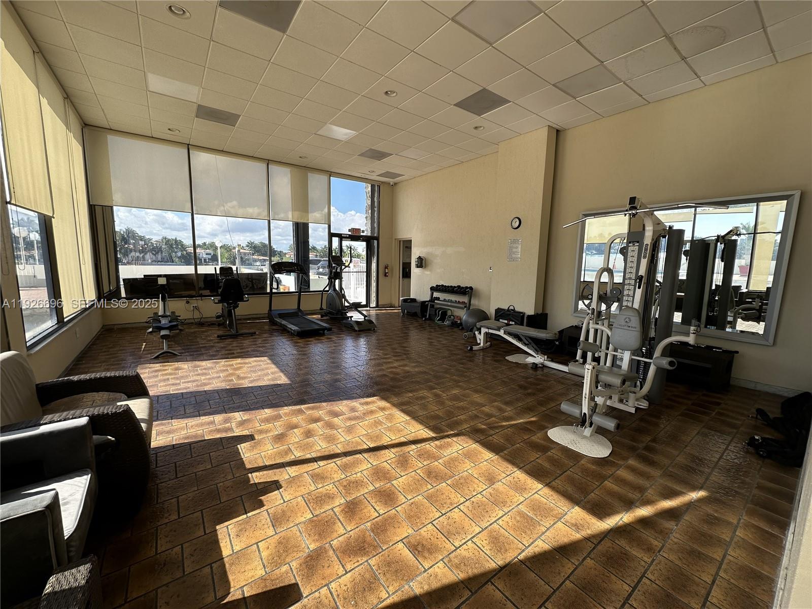 5838 Collins Avenue, Unit 11D Miami Beach, FL 33140 - Photo 23 of 24 a gym with lots of furniture and rug floor