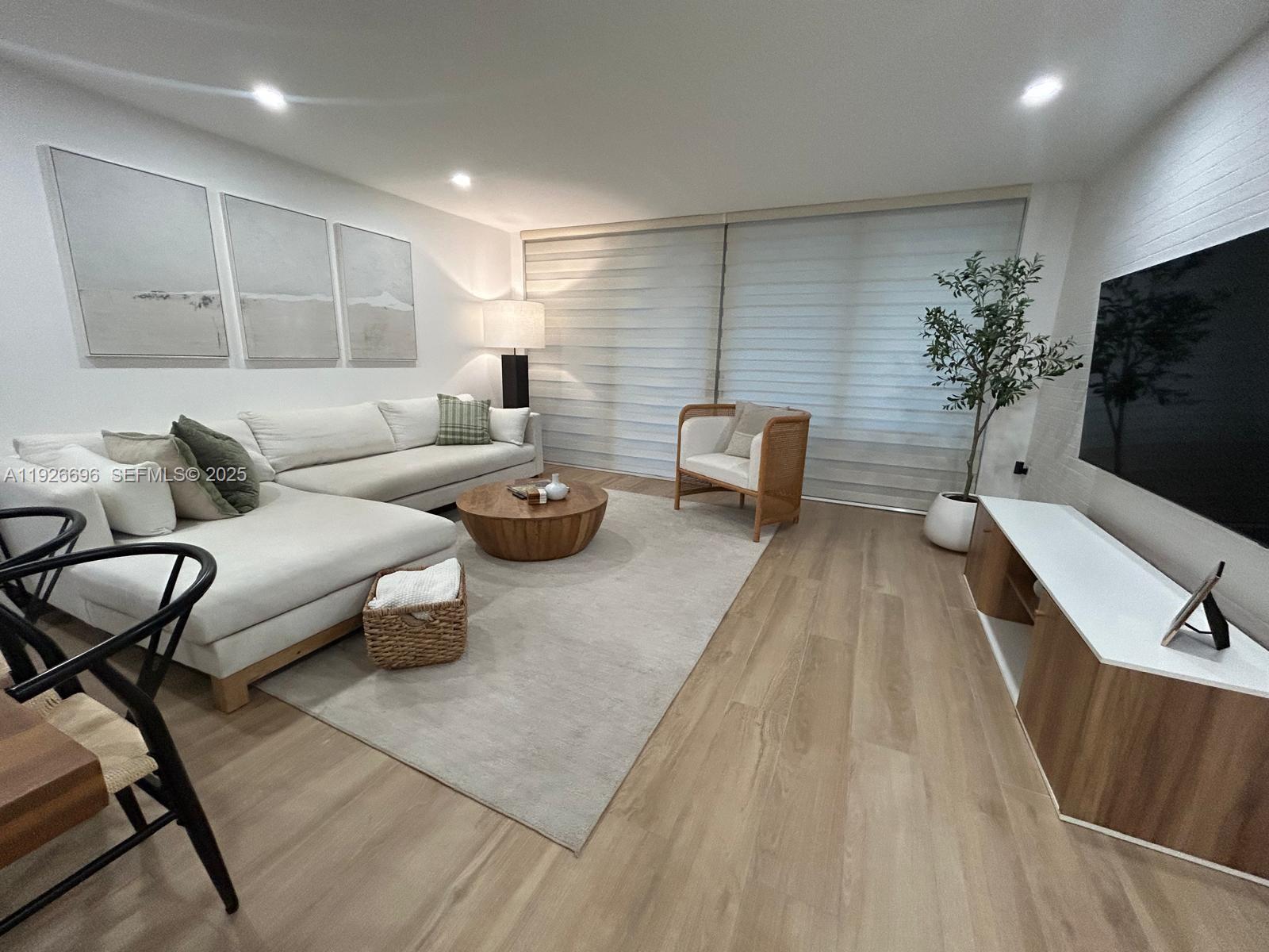 5838 Collins Avenue, Unit 11D Miami Beach, FL 33140 - Photo 5 of 24 a living room with furniture and a flat screen tv