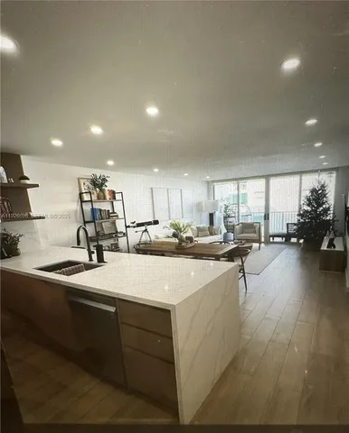 a kitchen with sink refrigerator and cabinets