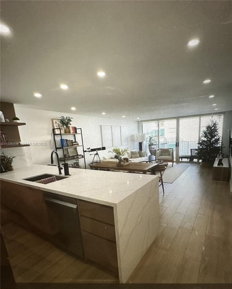 5838 Collins Avenue, Unit 11D Miami Beach, FL 33140 - Photo 6 of 24 a kitchen with sink refrigerator and cabinets