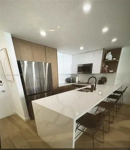 a kitchen with a table chairs refrigerator and microwave