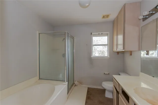 a bathroom with a sink a toilet and shower