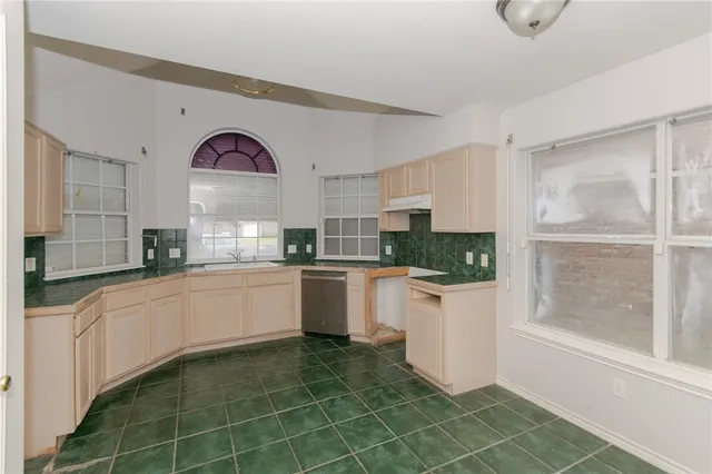 a kitchen with a sink a counter top space and stainless steel appliances