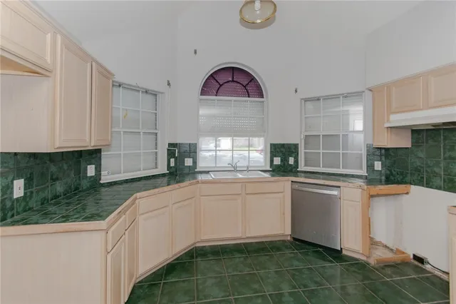 a kitchen with stainless steel appliances granite countertop a sink and a white cabinets