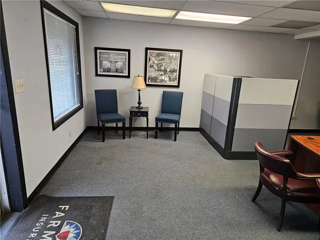 a living room with furniture and a painting on the wall